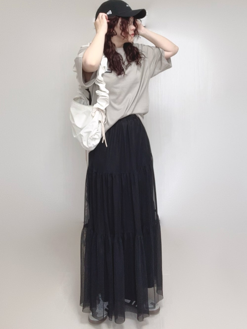 ベージュ系のTシャツ/カットソー、ホワイト系のショルダーバッグ、ブラック系のスカートを着用したレディースの夏コーディネートの3枚目の写真
