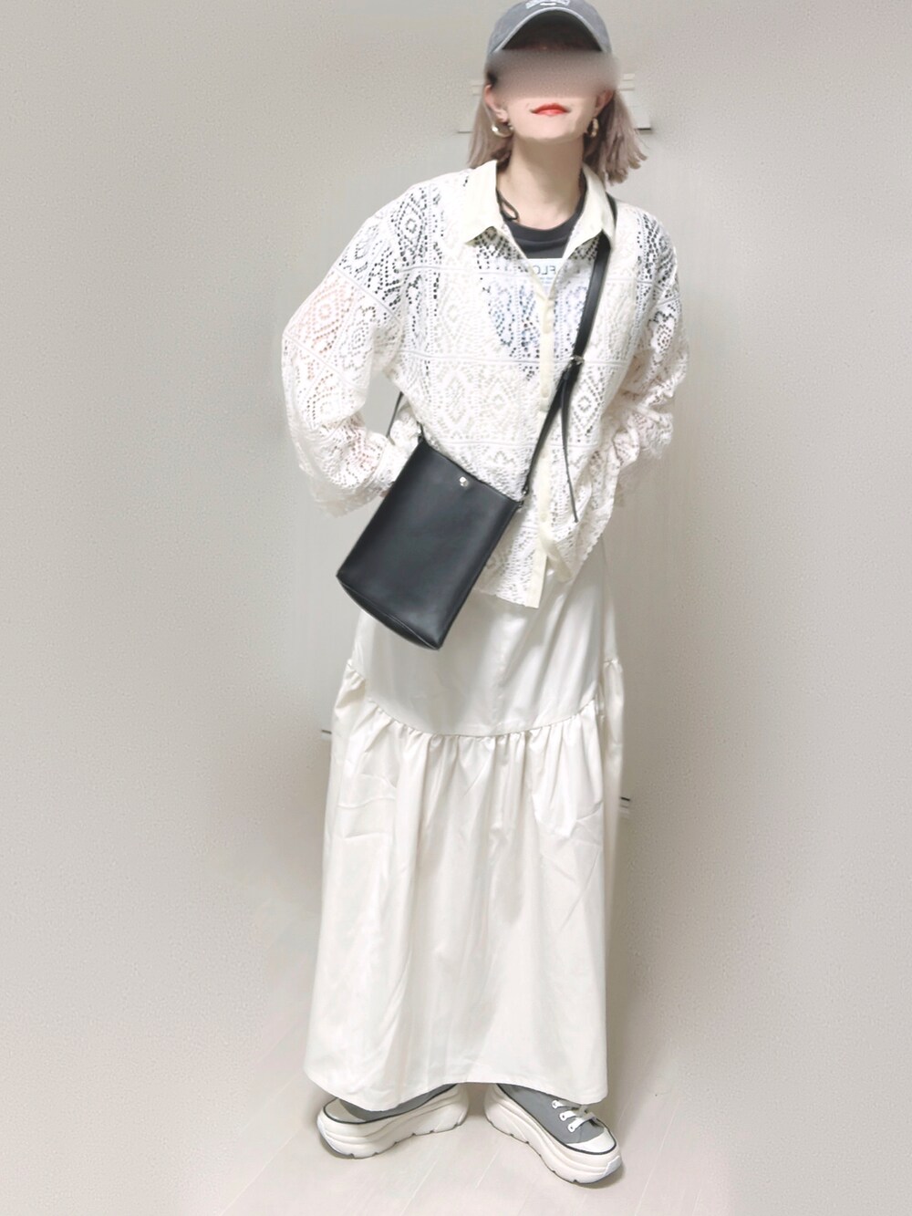 ホワイト系のジャンパースカート、ブラック系のショルダーバッグ、グレー系のスニーカーを着用したレディースの春コーディネートの4枚目の写真