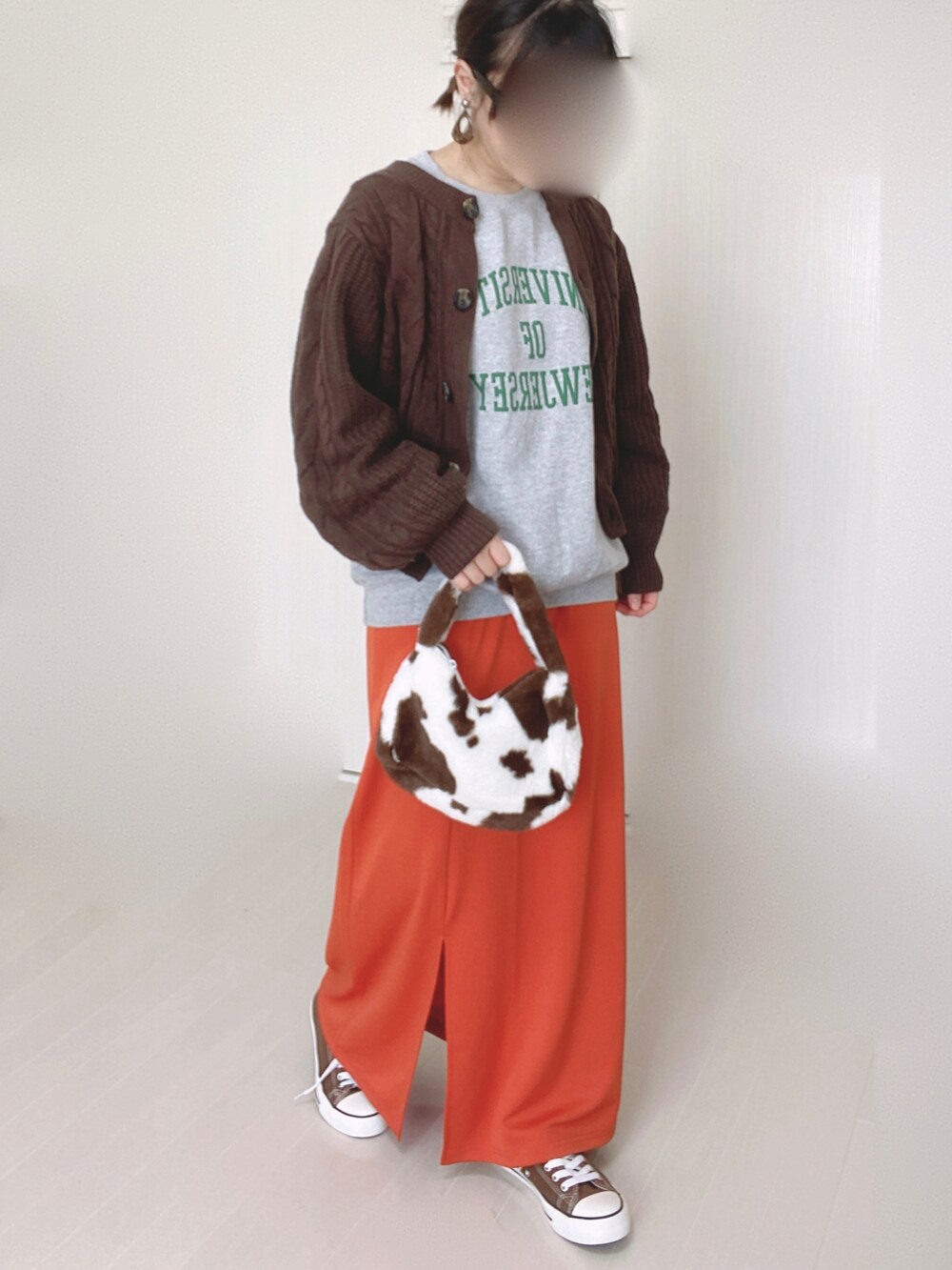グレー系のスウェット、オレンジ系のスカート、ブラウン系のニット/セーターを着用したレディースの秋コーディネートの5枚目の写真