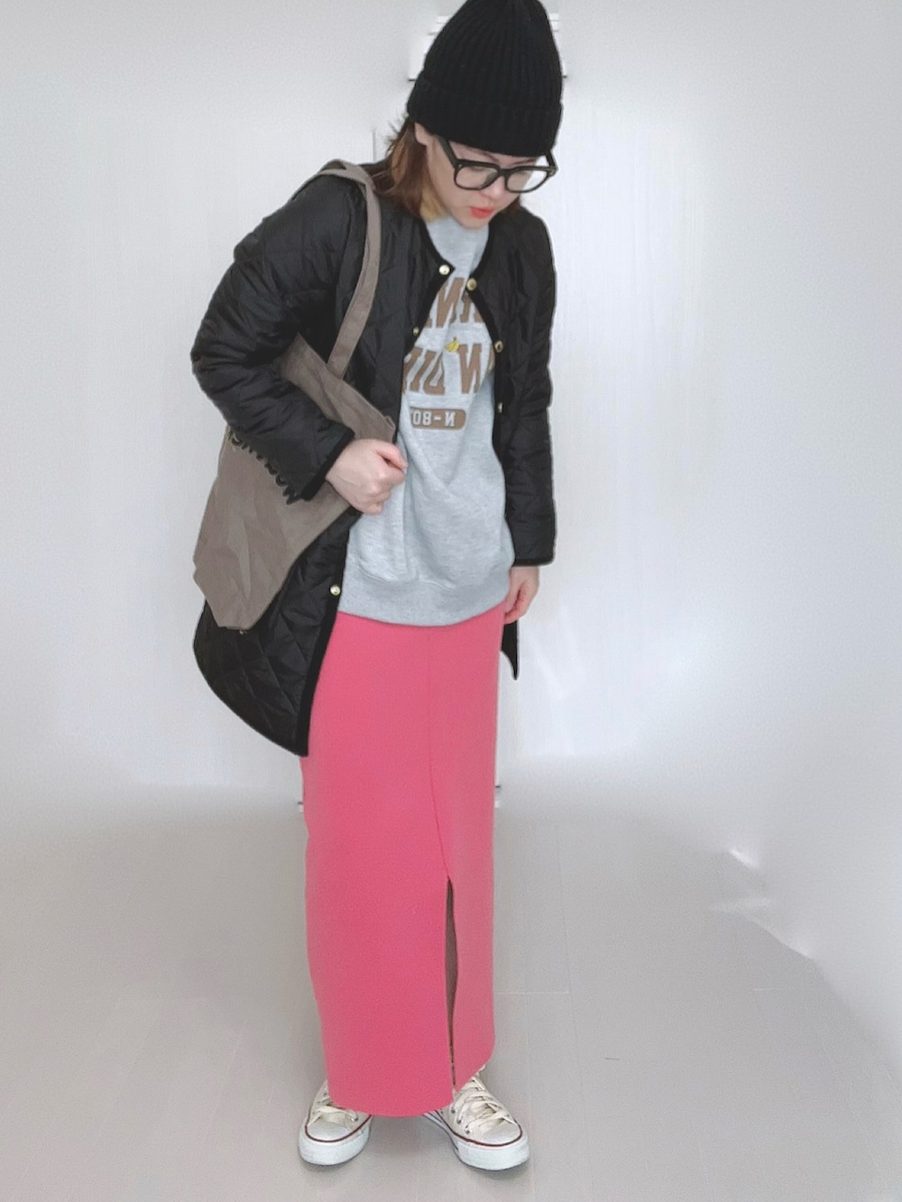 グレー系のスウェット、ブラック系のノーカラーコート、ブラウン系のトートバッグを着用したレディースの冬コーディネートの2枚目の写真