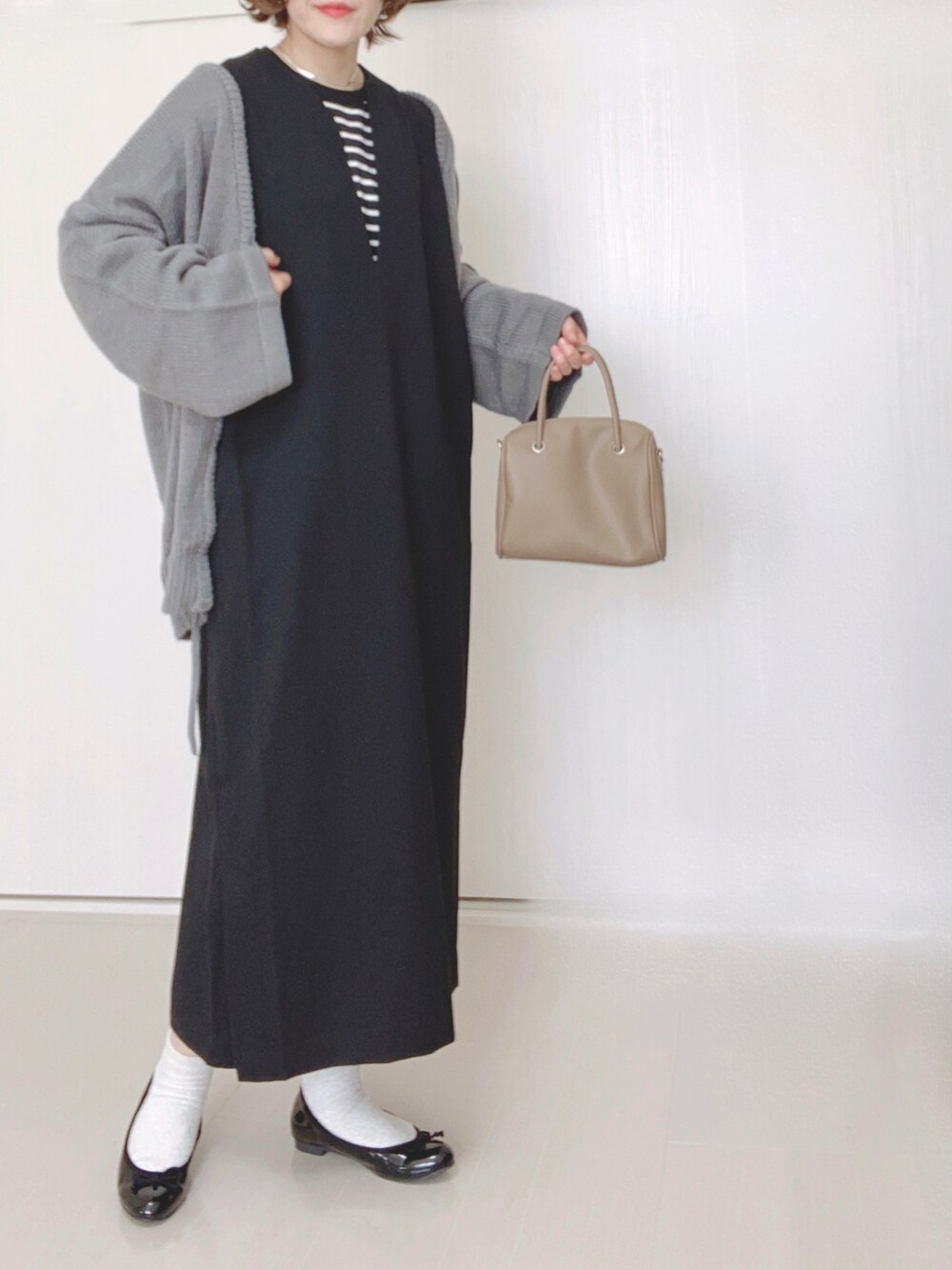 ブラック系のワンピース、グレー系のニット/セーター、ホワイト系のTシャツ/カットソーを着用したレディースの秋コーディネートの2枚目の写真