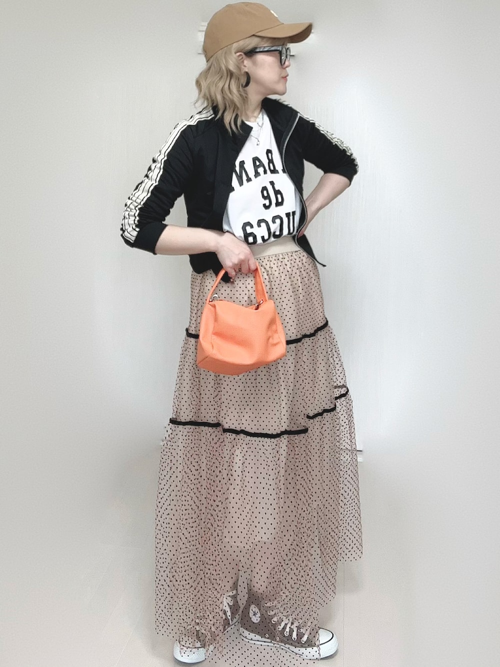 ベージュ系のスカート、ホワイト系のTシャツ/カットソー、ブラック系のジャージを着用したレディースの春コーディネートの4枚目の写真