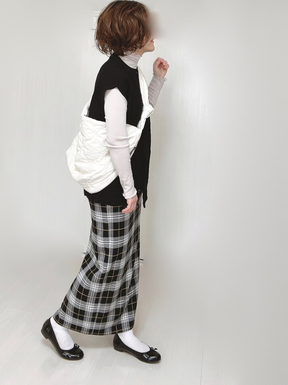 ブラック系のベスト、グレー系のTシャツ/カットソー、ホワイト系のショルダーバッグを着用したレディースの春コーディネートの2枚目の写真