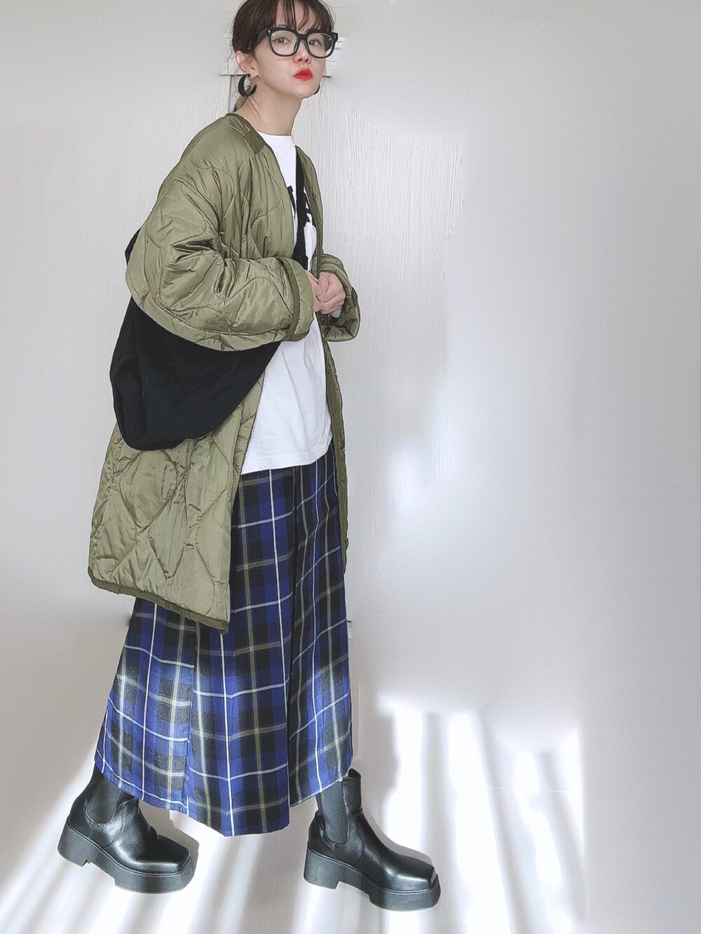 ホワイト系のTシャツ/カットソー、グリーン系のミリタリージャケット、ブラック系のブーツを着用したレディースの冬コーディネートの5枚目の写真