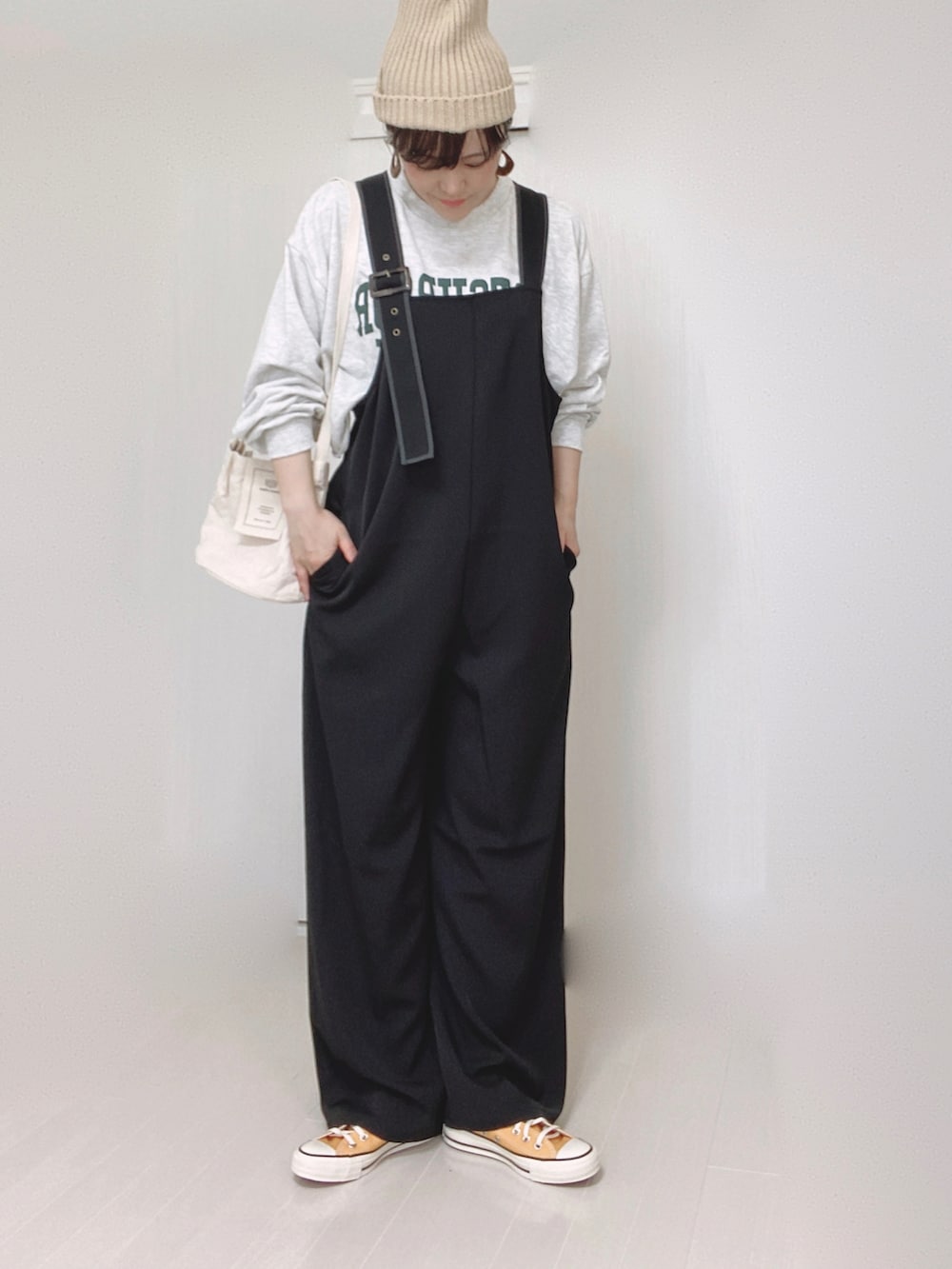 ブラック系のサロペット/オーバーオール、ベージュ系のニットキャップ/ビーニーを着用したレディースの夏コーディネートの2枚目の写真