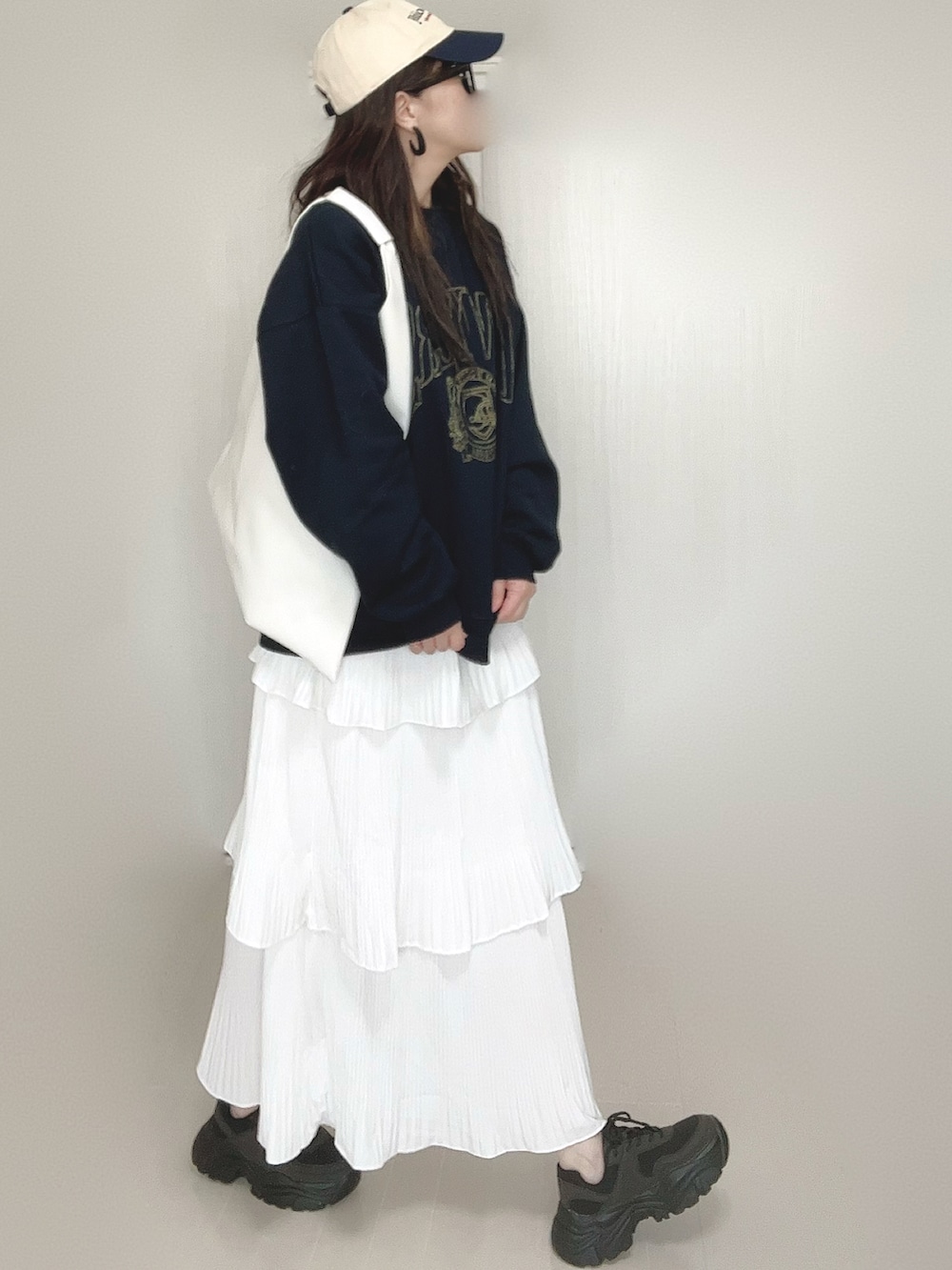 ブルー系のスウェット、ホワイト系のスカート、ホワイト系のショルダーバッグを着用したレディースの秋コーディネートの2枚目の写真