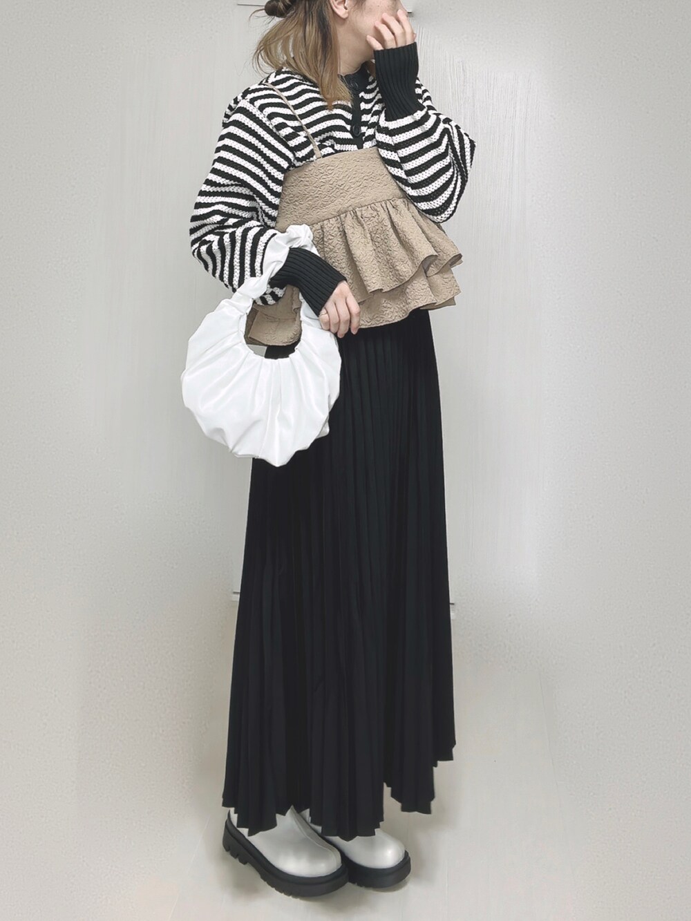 ホワイト系のカーディガン/ボレロ、ベージュ系のキャミソール、ブラック系のスカートを着用したレディースの秋コーディネートの3枚目の写真