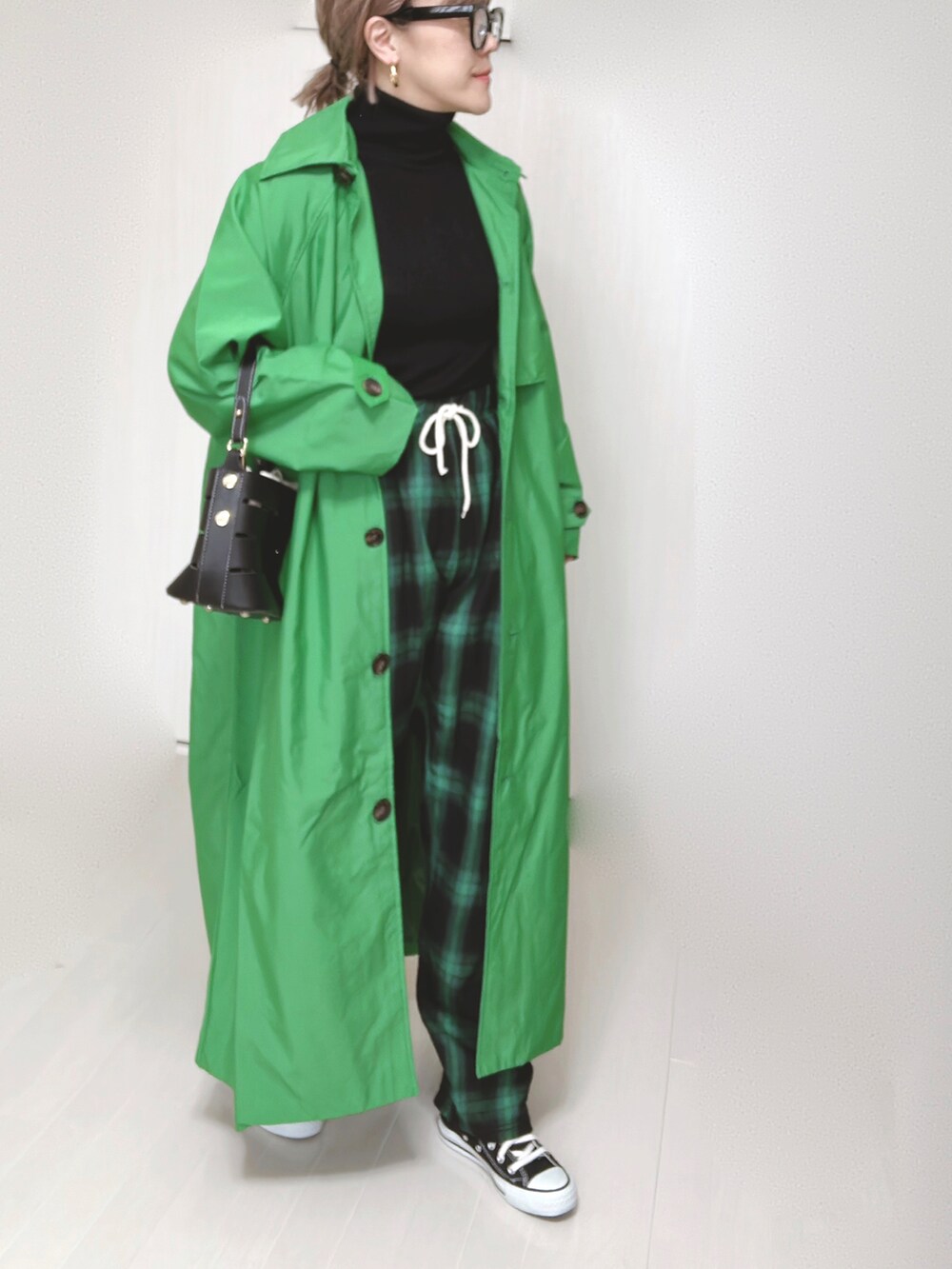 グリーン系のトレンチコート、グリーン系のその他パンツ、ブラック系のショルダーバッグを着用したレディースの春コーディネートの4枚目の写真