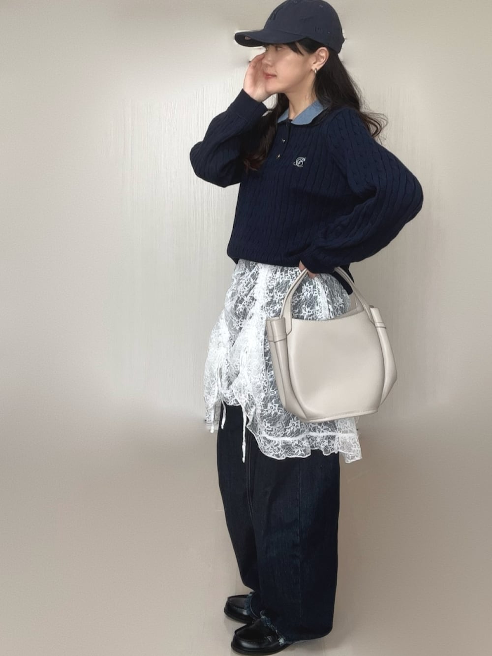 ブルー系のニット/セーター、ホワイト系のワンピース、ブラック系のデニムパンツを着用したレディースの冬コーディネートの4枚目の写真