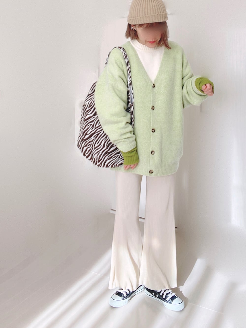 グリーン系のカーディガン/ボレロ、ホワイト系のニット/セーター、ホワイト系のその他パンツを着用したレディースの冬コーディネートの4枚目の写真