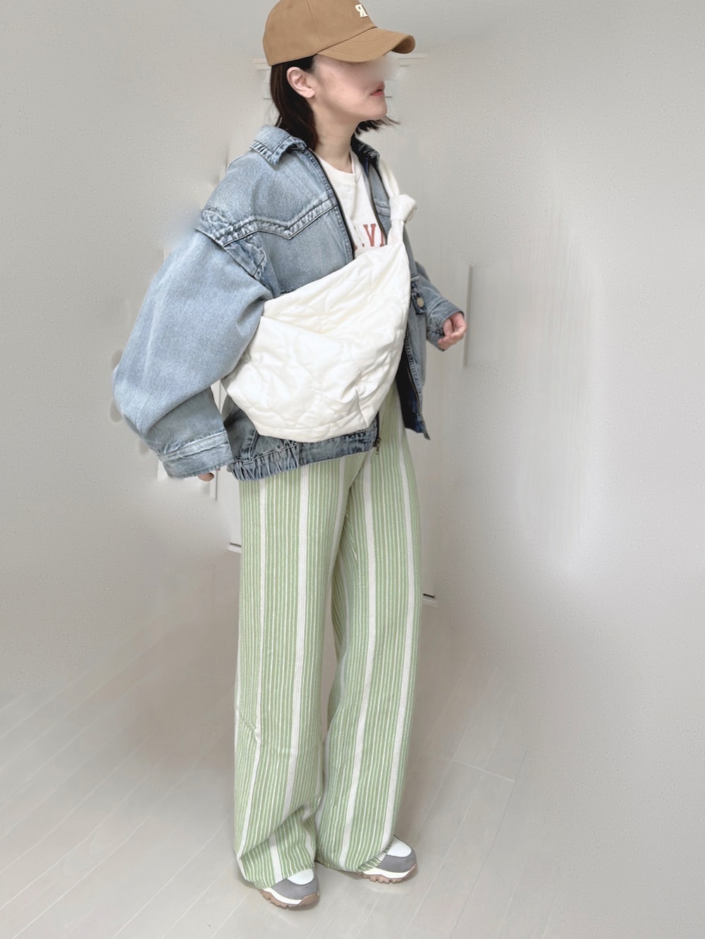 ブルー系のブルゾン、ホワイト系のショルダーバッグ、グリーン系のその他パンツを着用したレディースの春コーディネートの2枚目の写真