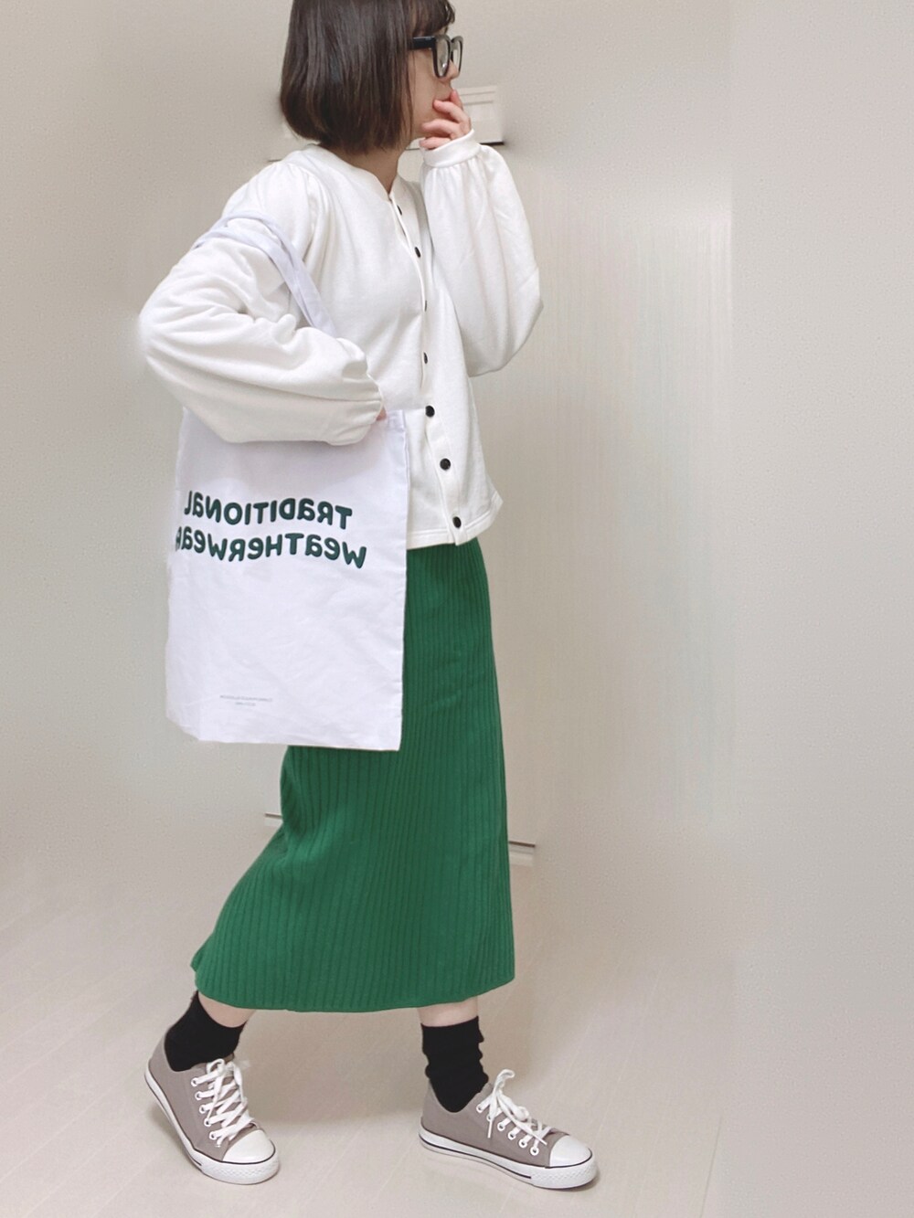 ブラック系のカーディガン/ボレロ、ホワイト系のトートバッグ、グリーン系のスカートを着用したレディースの春コーディネートの3枚目の写真