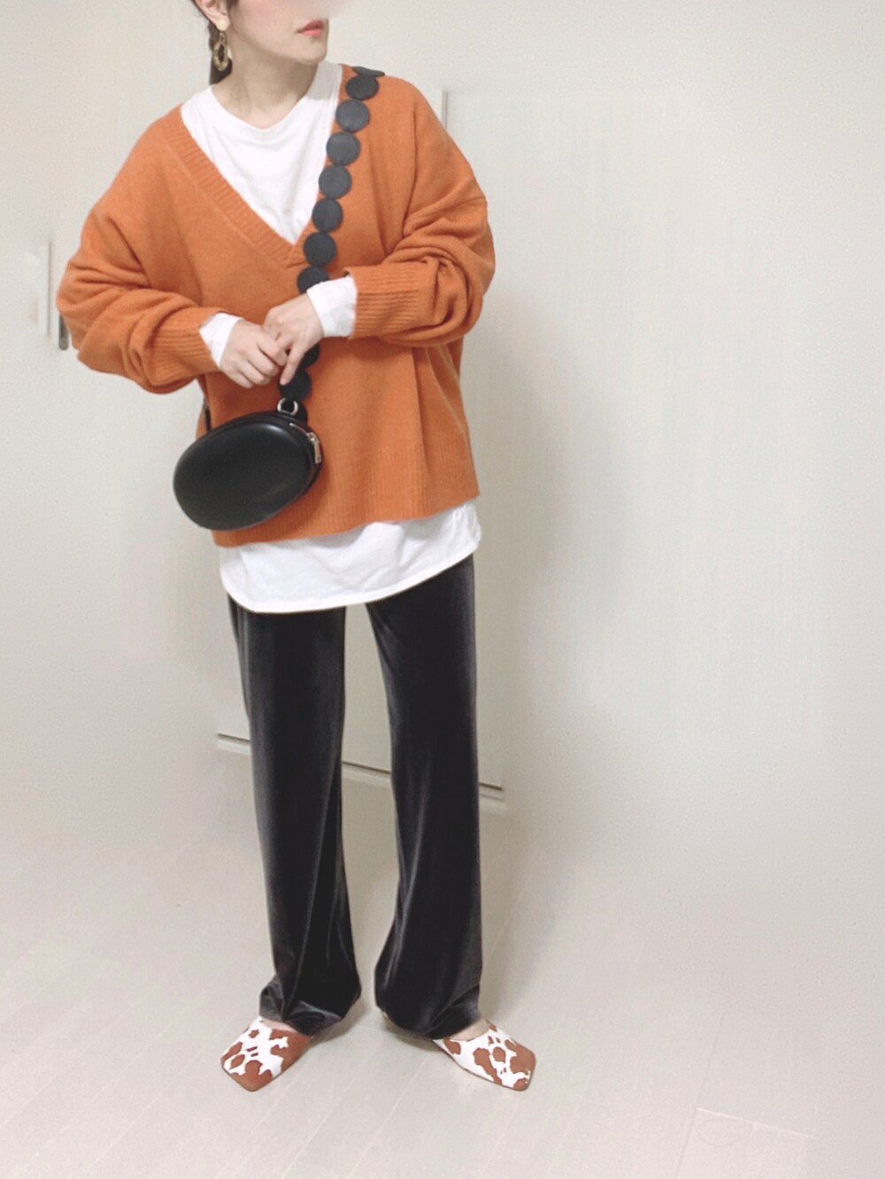 オレンジ系のニット/セーター、グレー系のその他パンツ、イエロー系のパンプスを着用したレディースの秋コーディネートの2枚目の写真