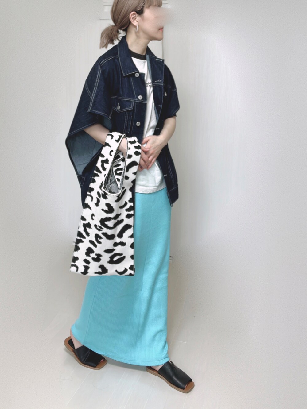 ブルー系のベスト、ブルー系のスカート、ブラック系のサンダルを着用したレディースの春コーディネートの2枚目の写真