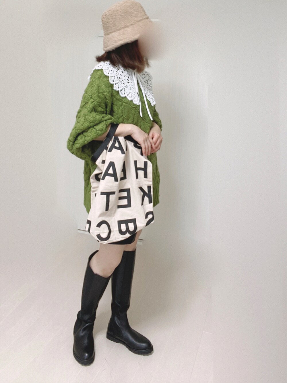 ブラック系のブーツ、グリーン系のニット/セーター、ホワイト系のトートバッグを着用したレディースの秋コーディネートの4枚目の写真