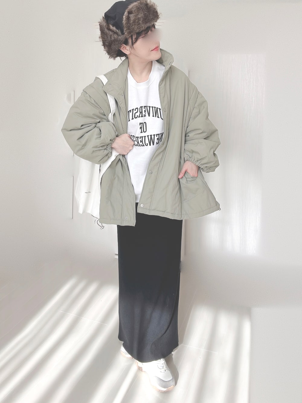 ホワイト系のスウェット、グリーン系のダウンジャケット/コート、ブラック系のスカートを着用したレディースの冬コーディネートの4枚目の写真