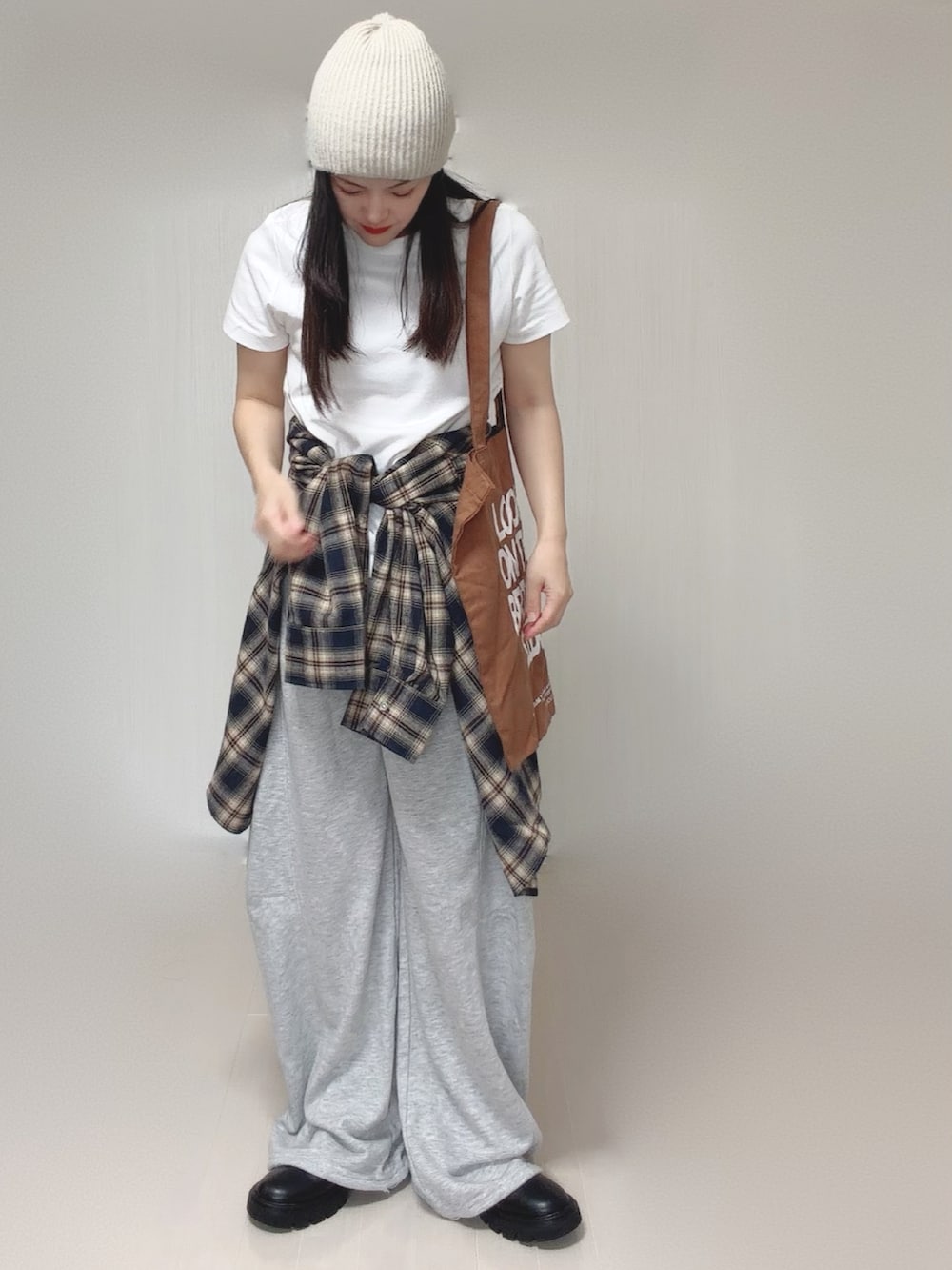 ブルー系のシャツ/ブラウス、グレー系のスウェットパンツ、ブラック系のブーツを着用したレディースの秋コーディネートの4枚目の写真