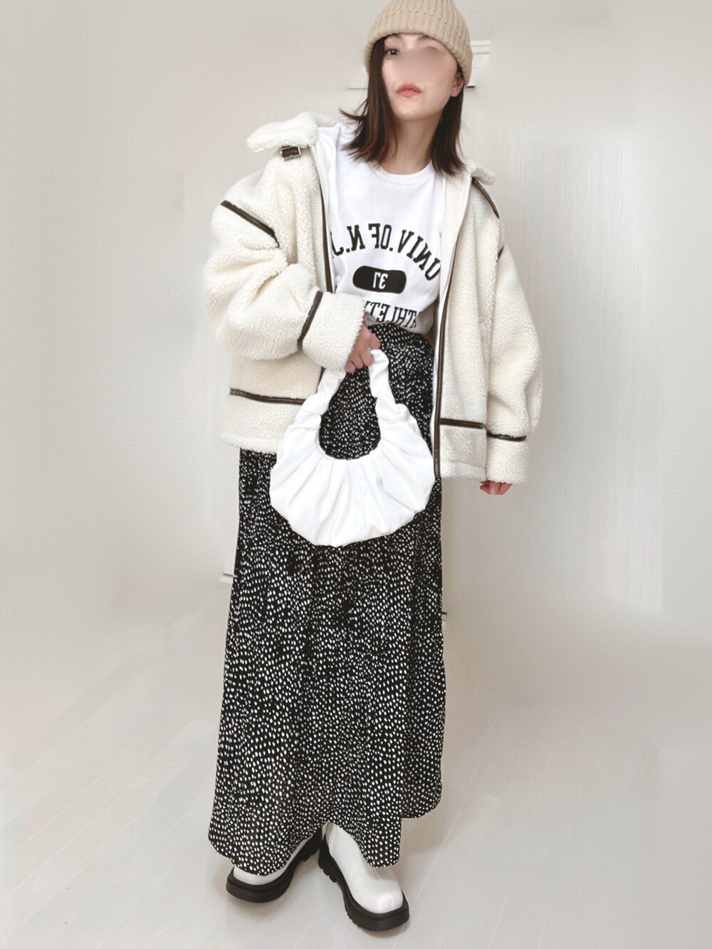 ホワイト系のTシャツ/カットソー、ホワイト系のブルゾン、ブラック系のスカートを着用したレディースの冬コーディネートの3枚目の写真