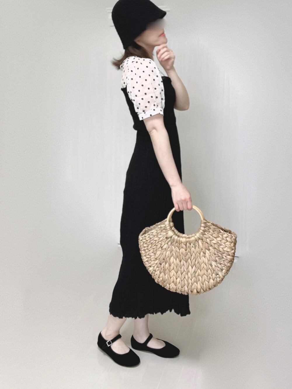 ベージュ系のかごバッグ、ブラック系のワンピース、ブラック系のパンプスを着用したレディースの夏コーディネートの5枚目の写真