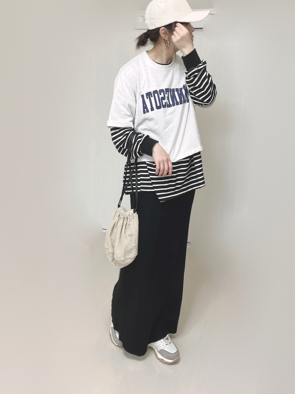 ホワイト系のTシャツ/カットソー、ベージュ系のハンドバッグ、ブラック系のスカートを着用したレディースの春コーディネートの5枚目の写真