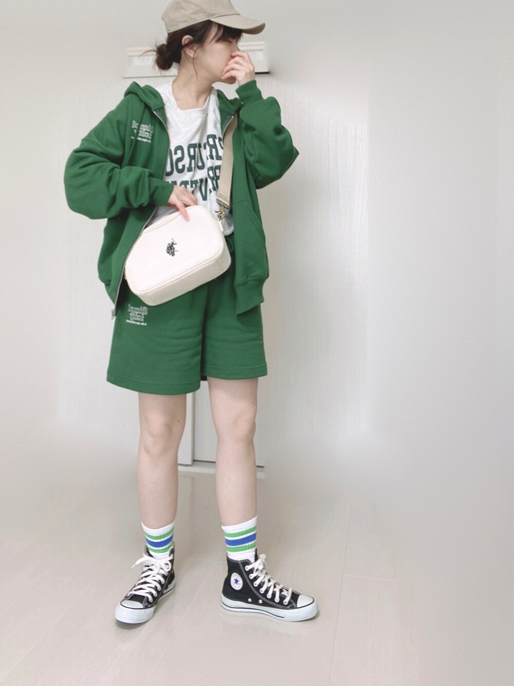 グリーン系のパーカー、グリーン系のその他パンツ、ホワイト系のショルダーバッグを着用したレディースの春コーディネートの3枚目の写真