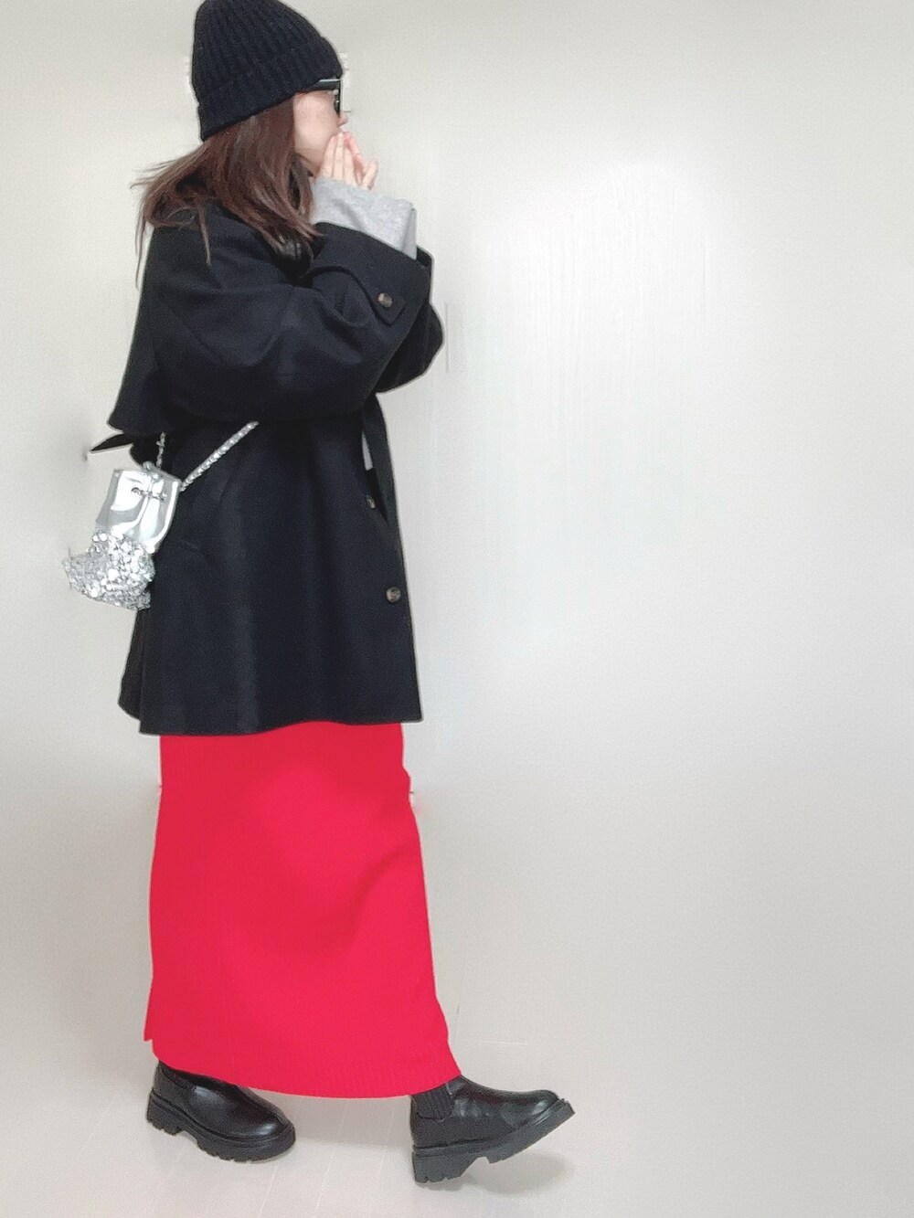 グレー系のトレンチコート、グレー系のワンピース、シルバー系のショルダーバッグを着用したレディースの秋コーディネートの3枚目の写真