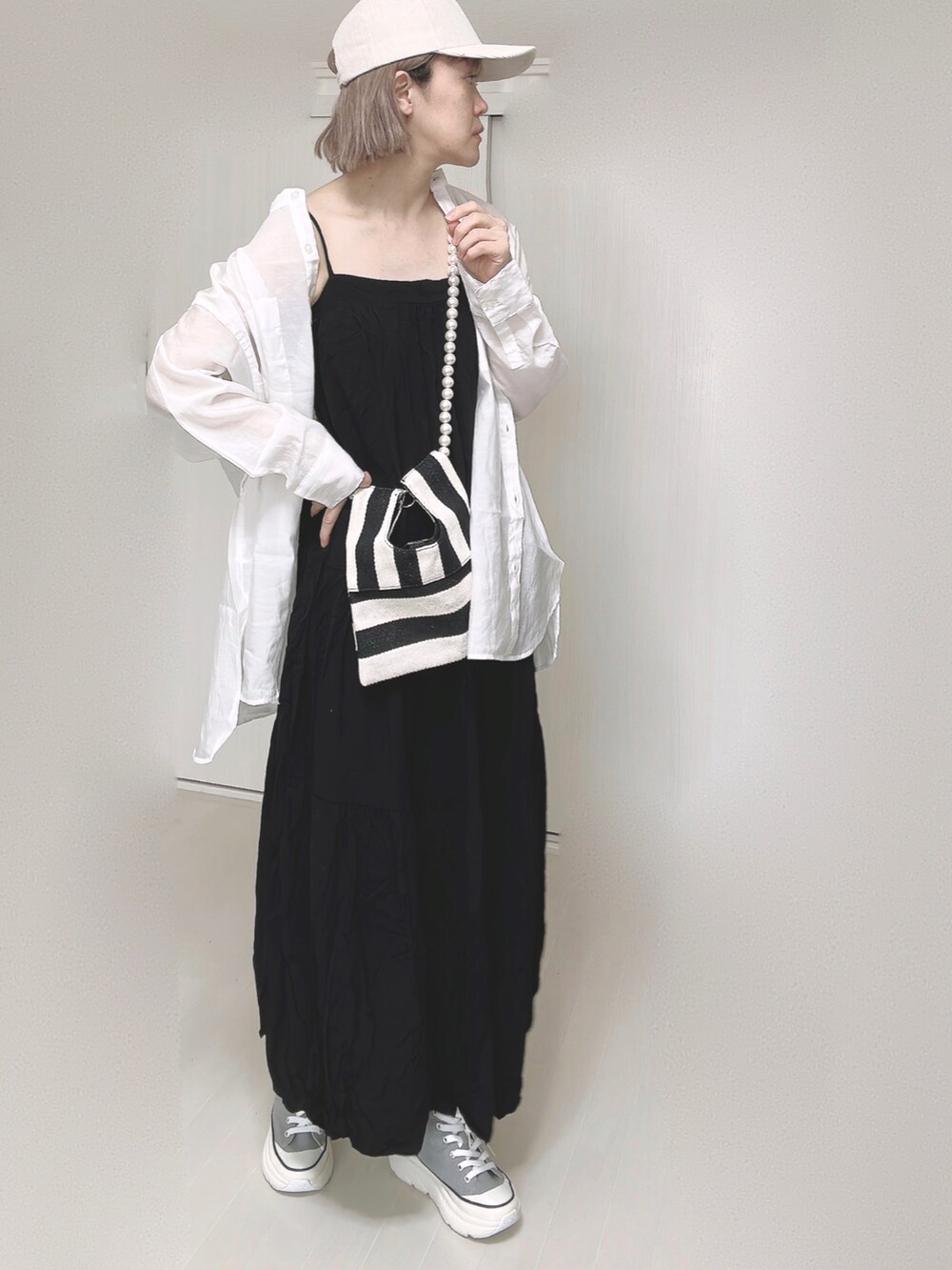 ブラック系のワンピース、ホワイト系のシャツ/ブラウス、ホワイト系のショルダーバッグを着用したレディースの春コーディネートの3枚目の写真