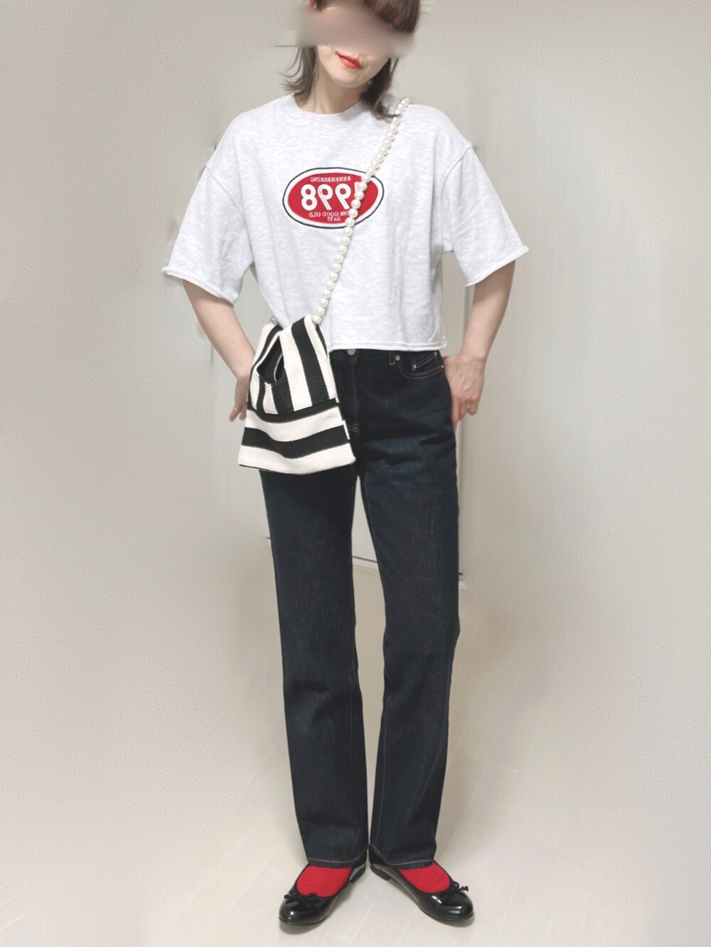 ホワイト系のショルダーバッグ、ブルー系のデニムパンツ、ブラック系のバレエシューズを着用したレディースの夏コーディネートの3枚目の写真