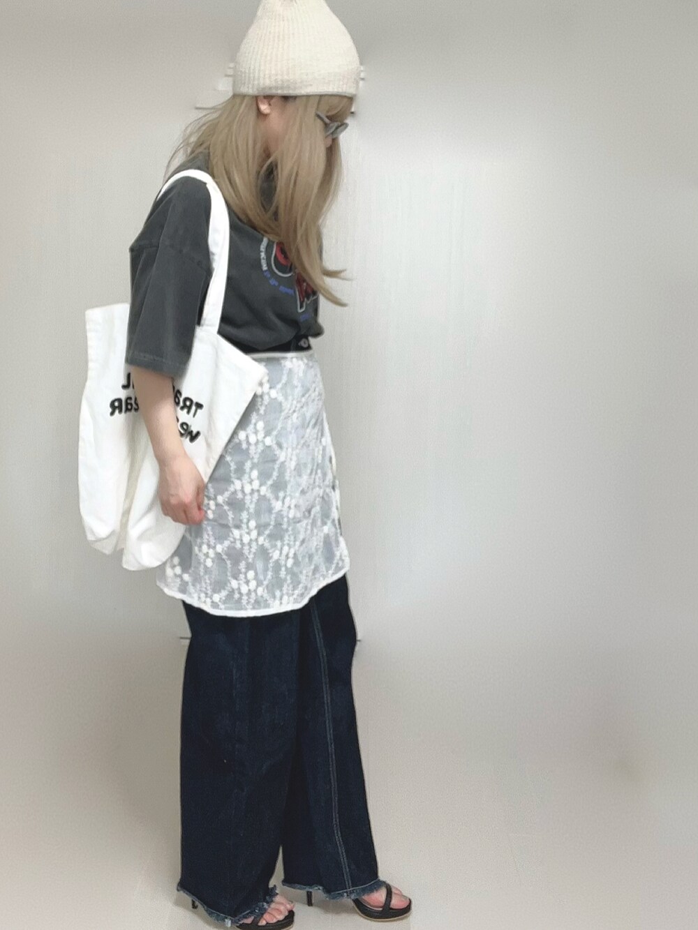 グレー系のTシャツ/カットソー、ホワイト系のトートバッグ、ブラック系のサンダルを着用したレディースの春コーディネートの3枚目の写真