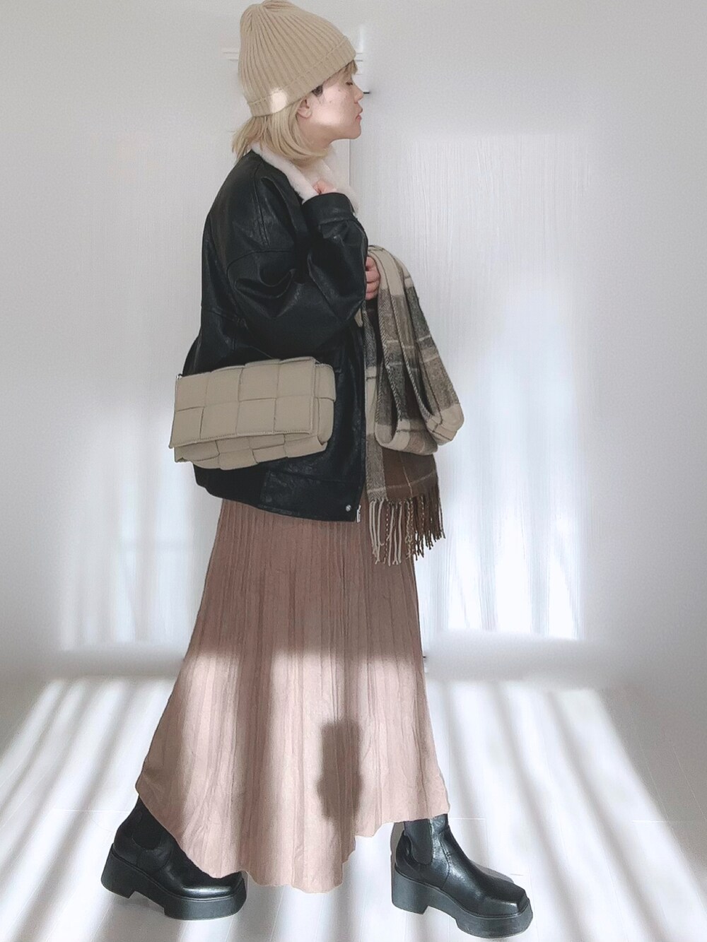 ブラック系のブルゾン、ブラウン系のスカート、ブラック系のブーツを着用したレディースの冬コーディネートの2枚目の写真