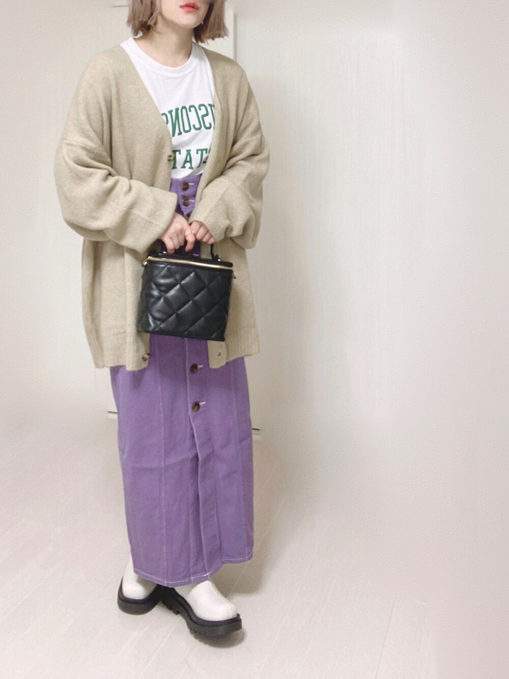 ベージュ系のカーディガン/ボレロ、ホワイト系のTシャツ/カットソー、パープル系のスカートを着用したレディースの冬コーディネートの4枚目の写真
