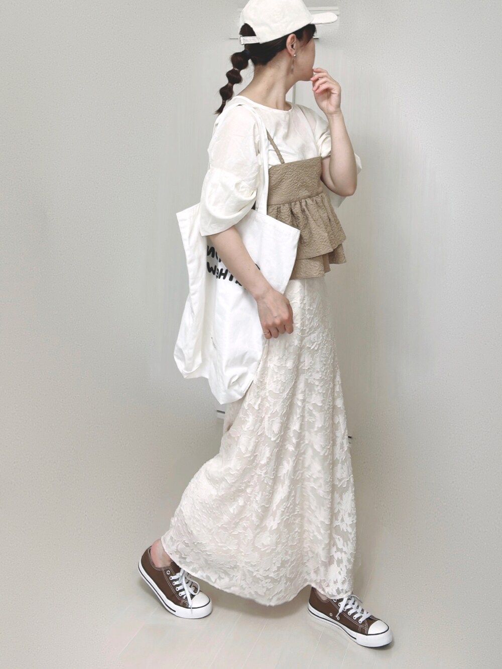ホワイト系のスカート、ホワイト系のシャツ/ブラウス、ベージュ系のキャミソールを着用したレディースの夏コーディネートの2枚目の写真