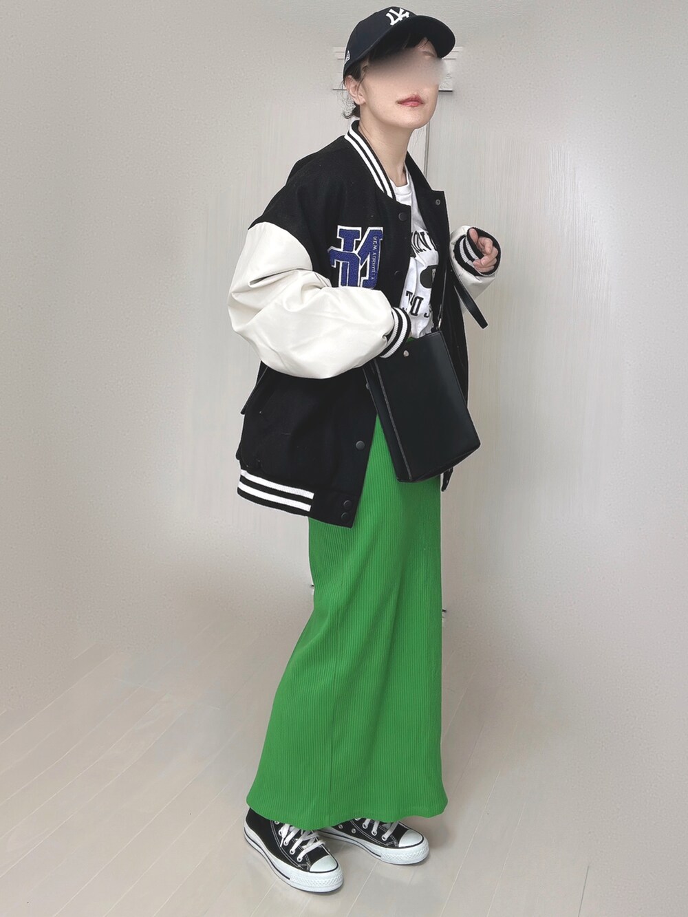 ブラック系のスタジャン、ホワイト系のTシャツ/カットソー、グリーン系のスカートを着用したレディースの冬コーディネートの2枚目の写真