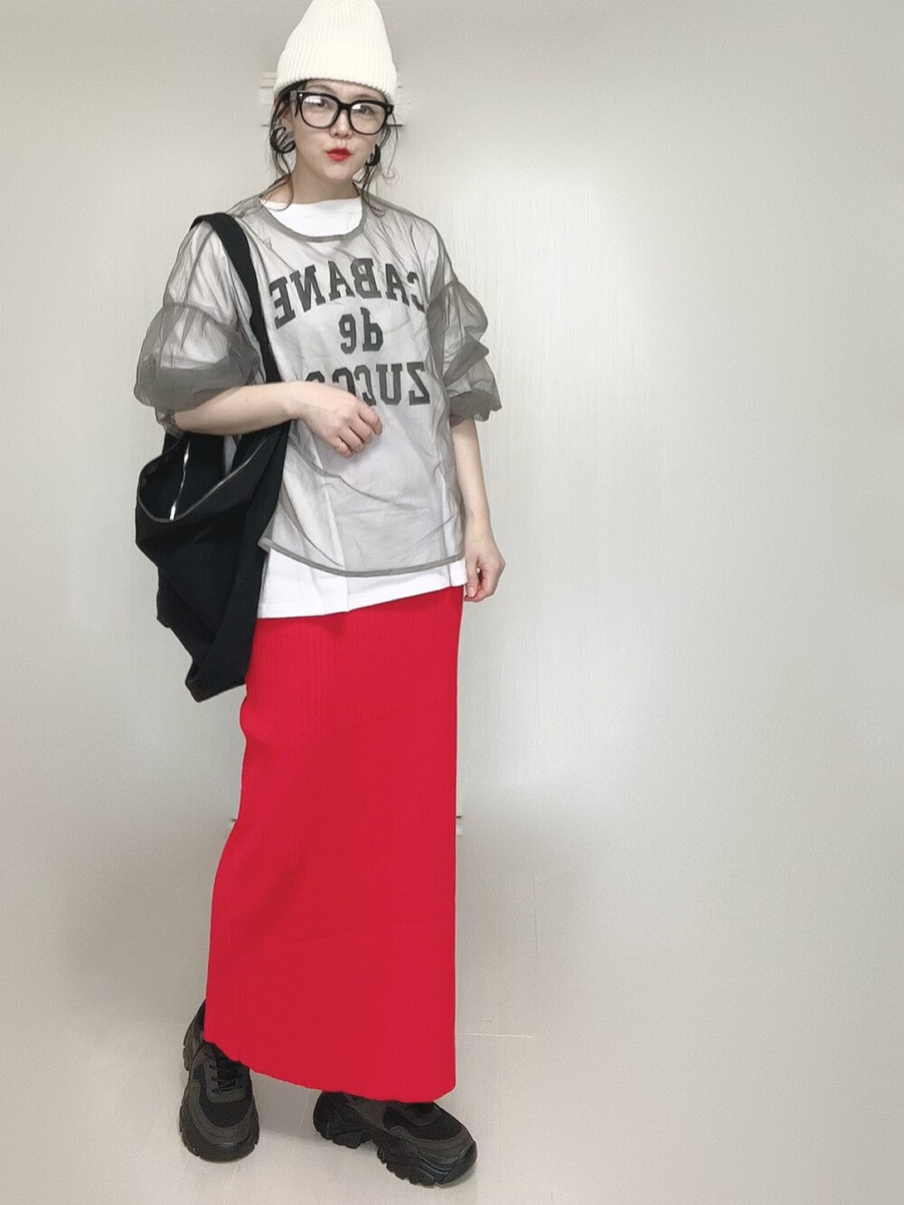 ホワイト系のTシャツ/カットソー、レッド系のスカート、ブラック系のスニーカーを着用したレディースの春コーディネートの2枚目の写真