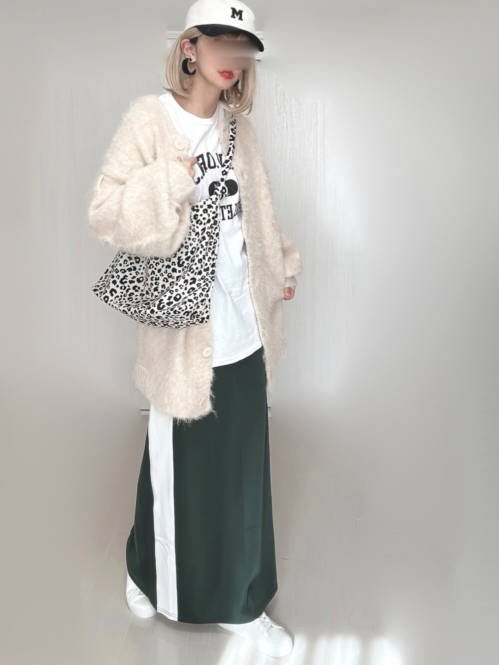 ホワイト系のトートバッグ、ベージュ系のカーディガン/ボレロ、ホワイト系のTシャツ/カットソーを着用したレディースの秋コーディネートの2枚目の写真
