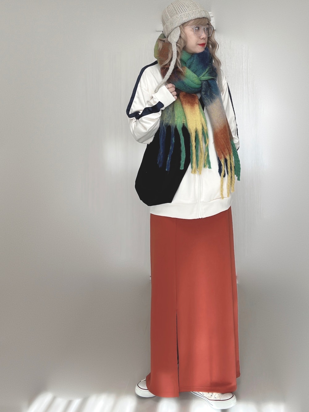 ベージュ系のジャージ、オレンジ系のスカート、ホワイト系のスニーカーを着用したレディースの秋コーディネートの5枚目の写真