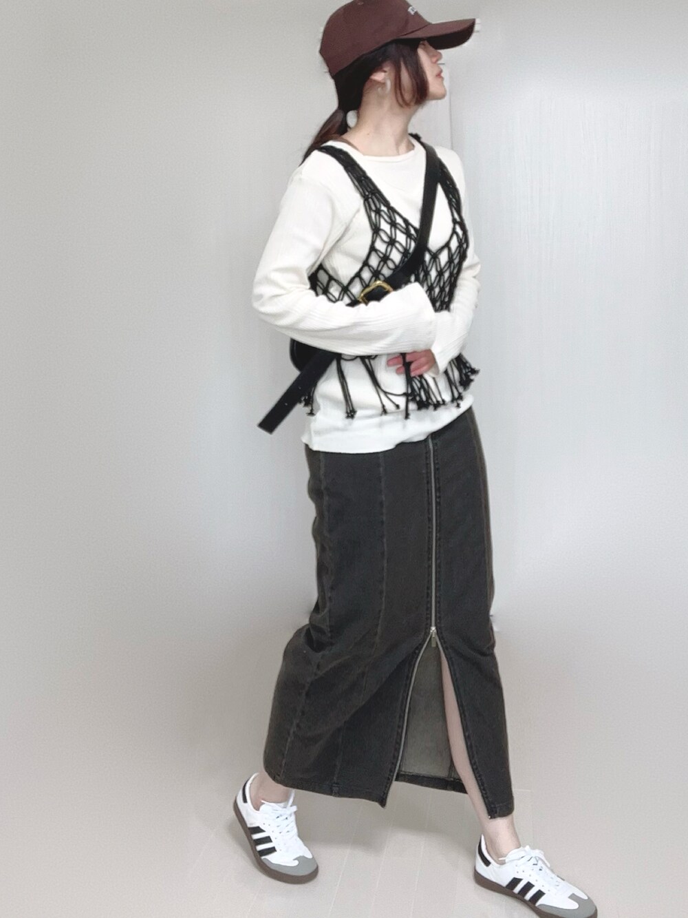 ブラック系のスカート、ベージュ系のTシャツ/カットソー、ブラック系のベストを着用したレディースの春コーディネートの3枚目の写真