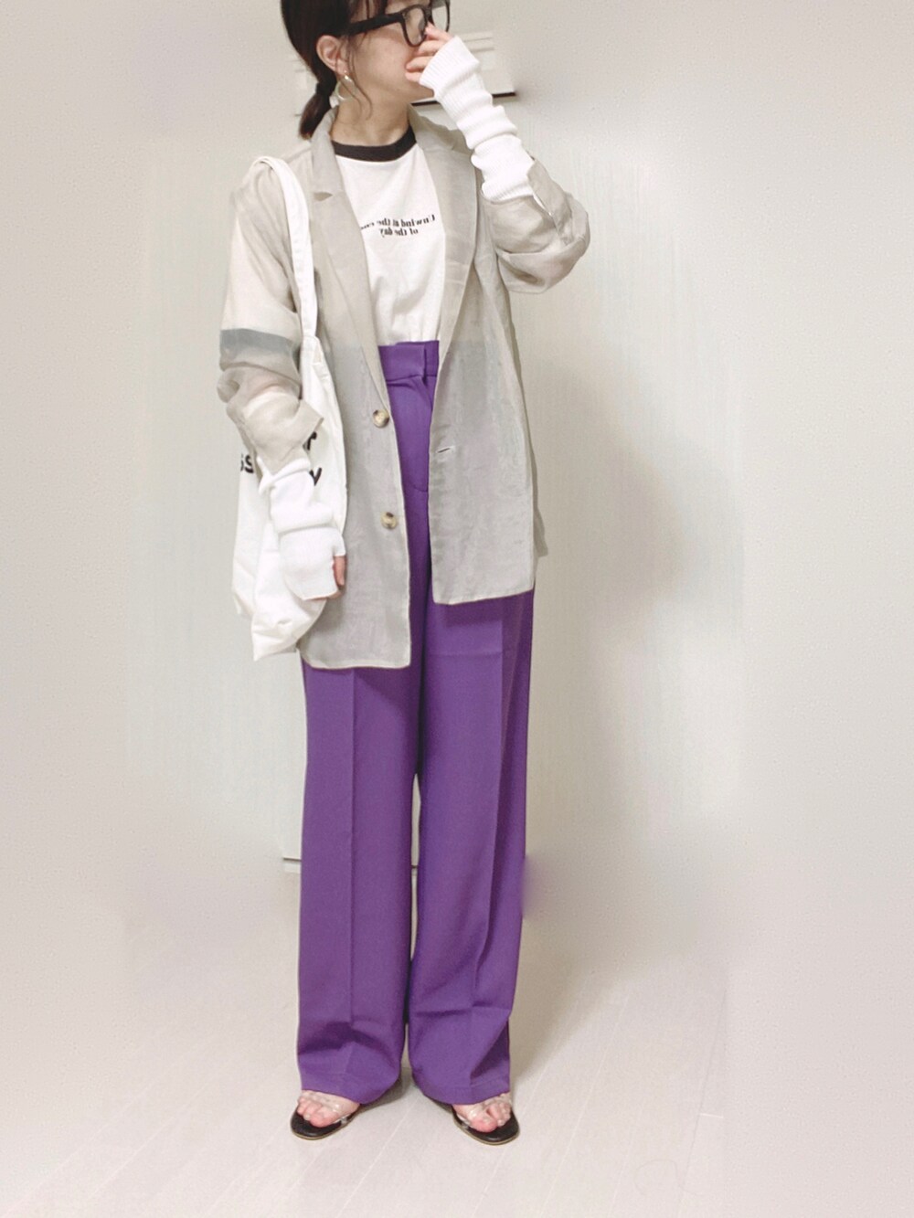 パープル系のスラックス、グレー系のテーラードジャケット、ホワイト系のトートバッグを着用したレディースの秋コーディネートの4枚目の写真