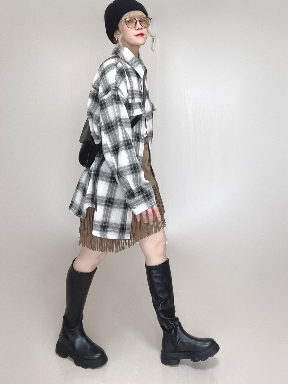 ホワイト系のシャツ/ブラウス、ベージュ系のスカート、ブラック系のブーツを着用したレディースの秋コーディネートの2枚目の写真