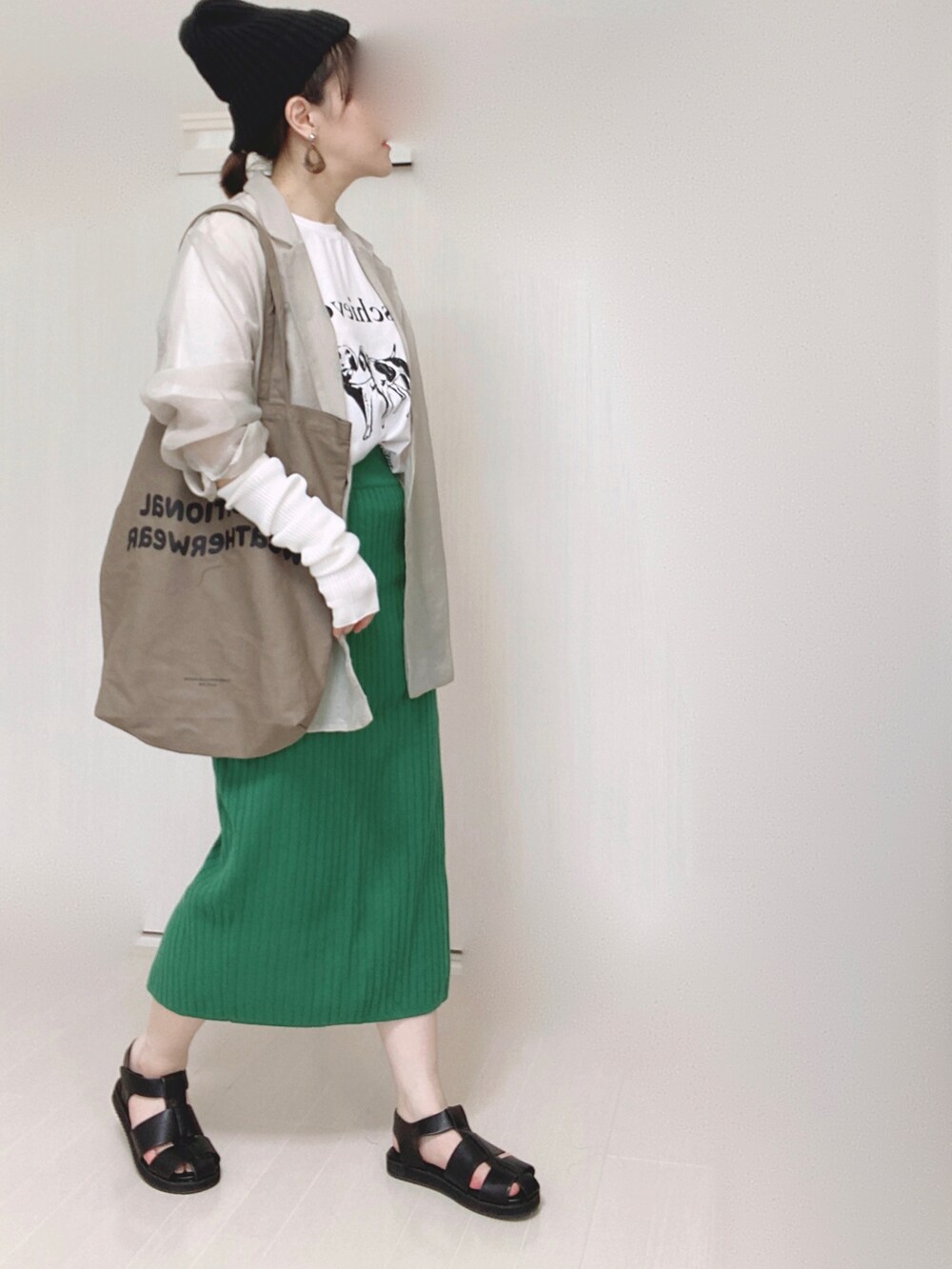 グレー系のテーラードジャケット、ブラウン系のトートバッグ、グリーン系のスカートを着用したレディースの夏コーディネートの2枚目の写真