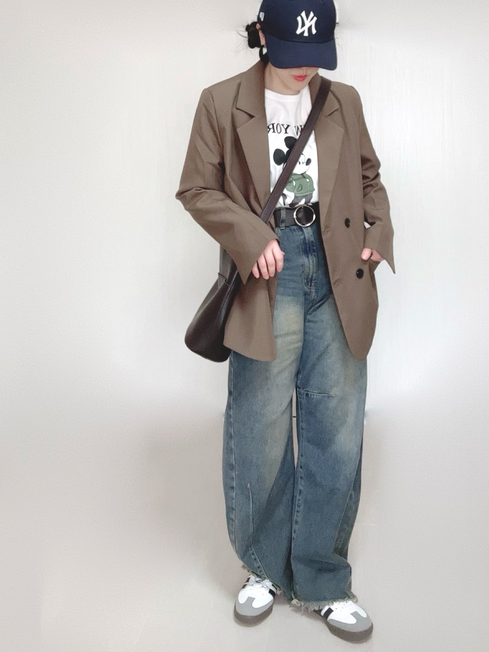 ブラウン系のテーラードジャケット、ホワイト系のTシャツ/カットソー、ブルー系のデニムパンツを着用したレディースの冬コーディネートの3枚目の写真