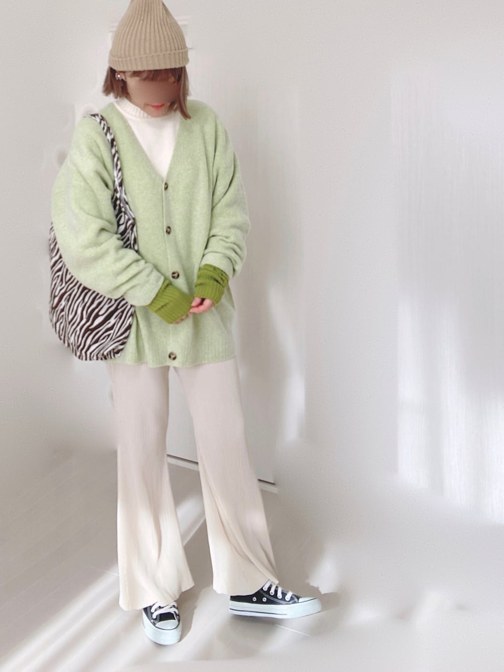グリーン系のカーディガン/ボレロ、ホワイト系のニット/セーター、ホワイト系のその他パンツを着用したレディースの冬コーディネートの5枚目の写真