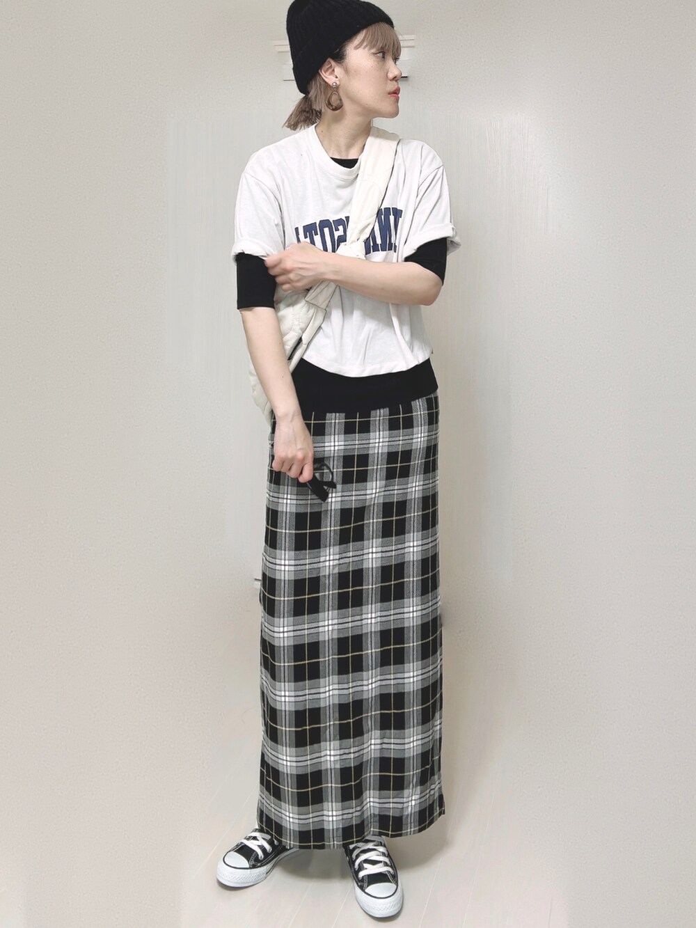 ブラック系のスカート、ブラック系のTシャツ/カットソー、ホワイト系のショルダーバッグを着用したレディースの夏コーディネートの4枚目の写真