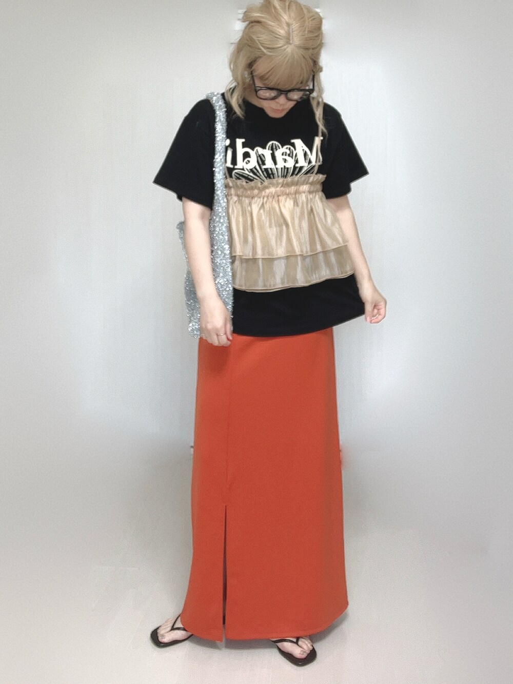 オレンジ系のキャミソール、ブラック系のTシャツ/カットソー、オレンジ系のスカートを着用したレディースの夏コーディネートの4枚目の写真
