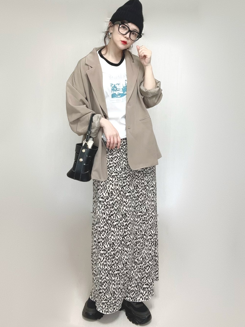 ホワイト系のTシャツ/カットソー、ベージュ系のセットアップ、ブラック系のショルダーバッグを着用したレディースの春コーディネートの3枚目の写真