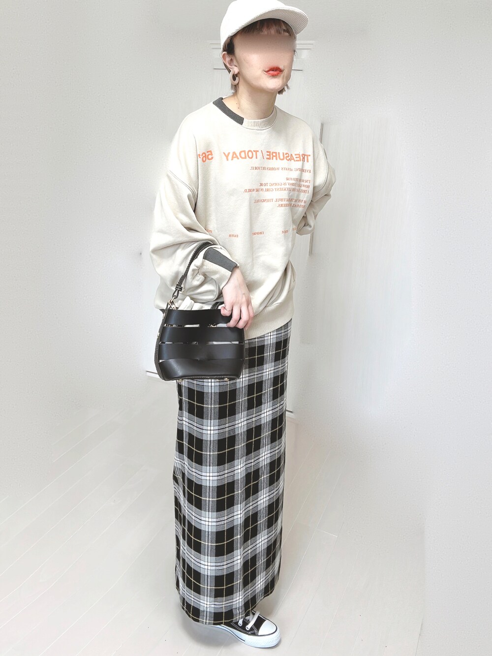 ベージュ系のスウェット、ブラック系のスカート、ブラック系のショルダーバッグを着用したレディースの春コーディネートの5枚目の写真