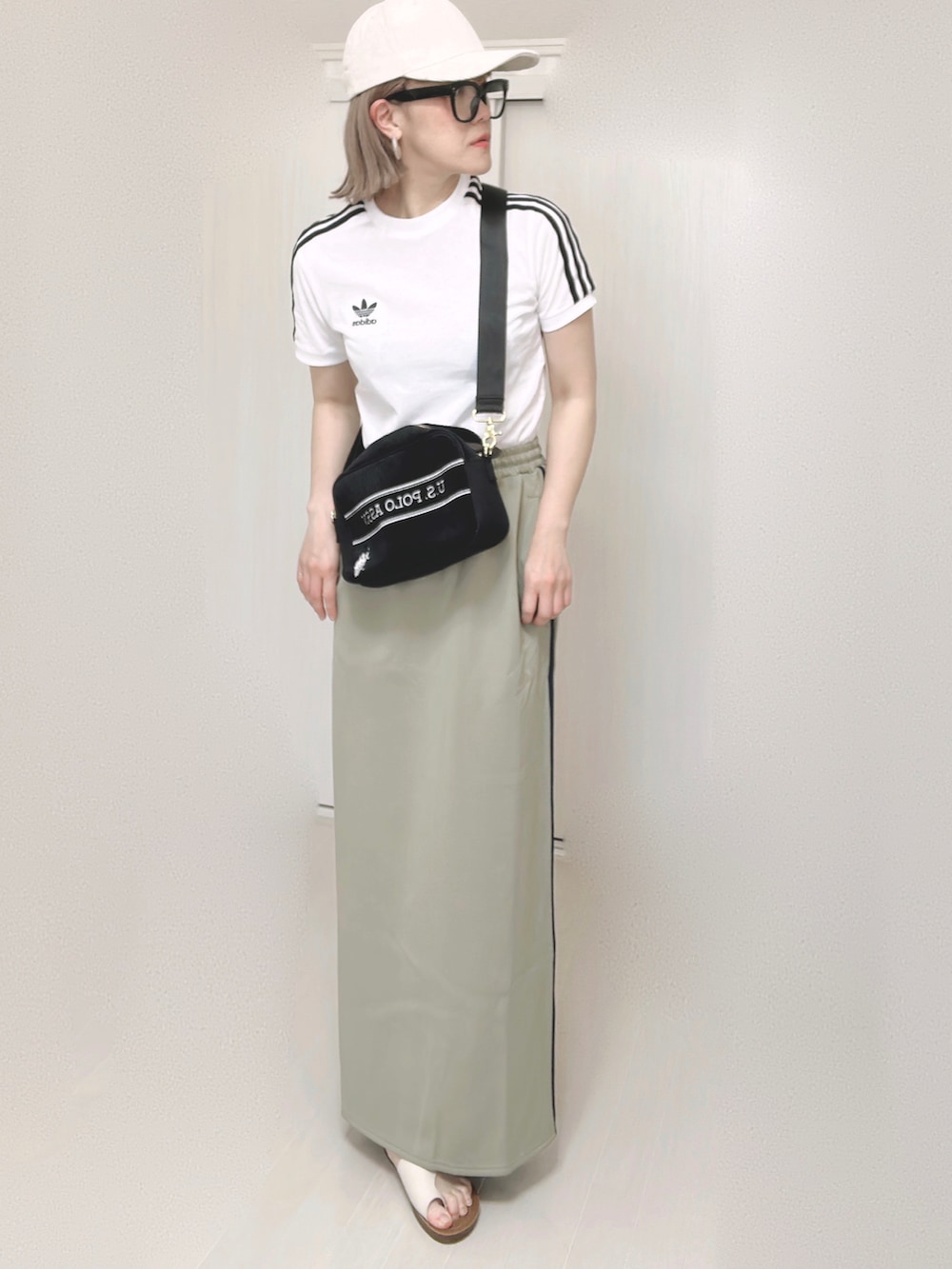 ホワイト系のTシャツ/カットソー、ブラック系のショルダーバッグ、ブルー系のスカートを着用したレディースの夏コーディネートの5枚目の写真