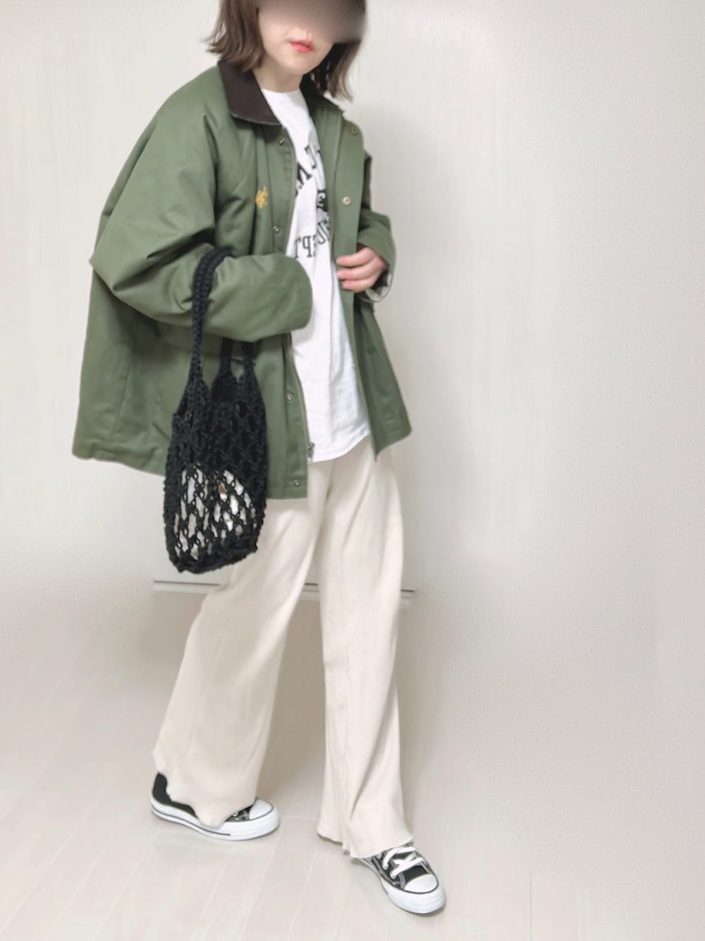 グリーン系のカバーオール、ホワイト系のTシャツ/カットソー、ブラック系のハンドバッグを着用したレディースの春コーディネートの5枚目の写真