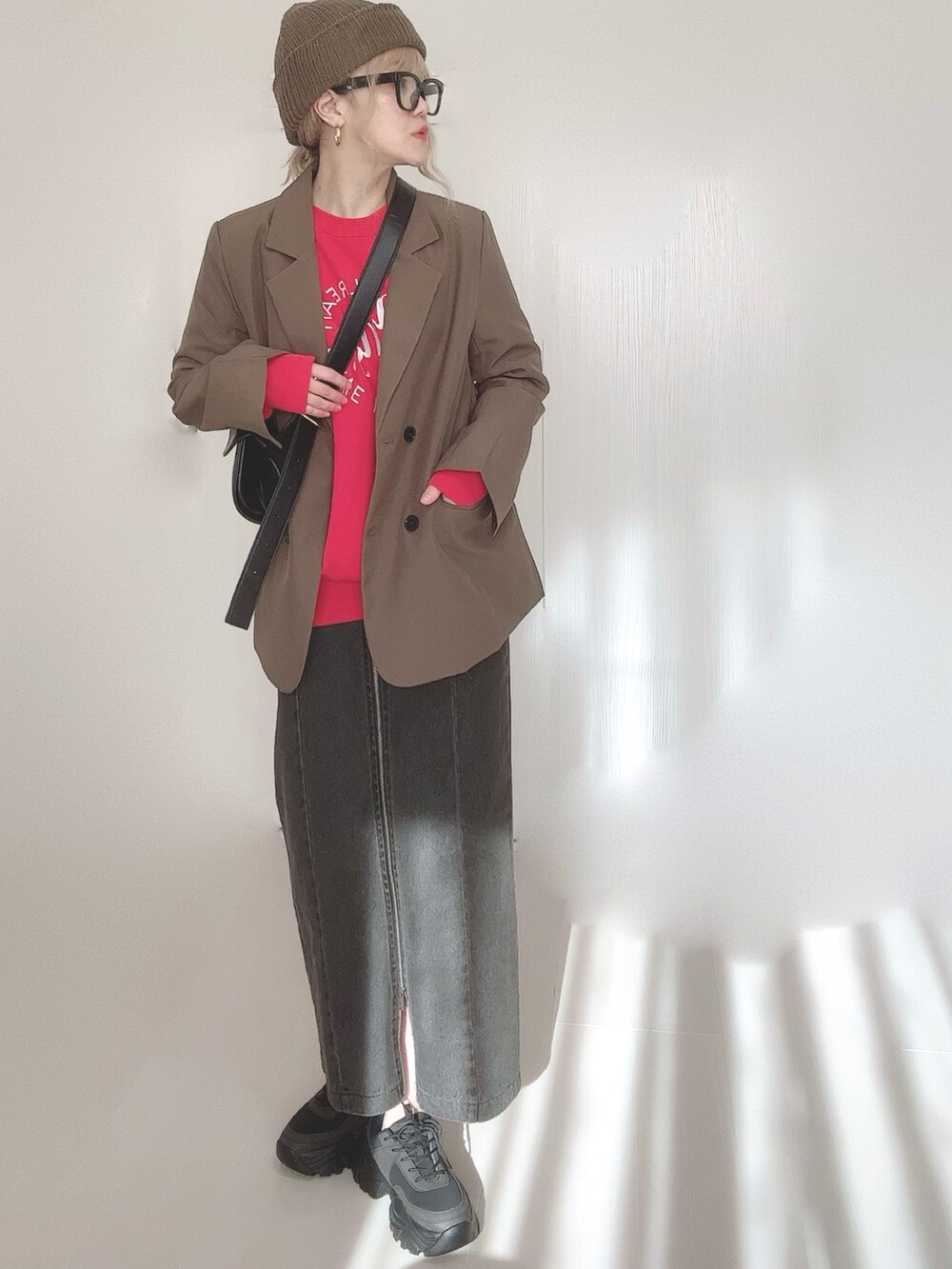 ブラック系のスカート、ブラウン系のテーラードジャケット、レッド系のスウェットを着用したレディースの冬コーディネートの3枚目の写真