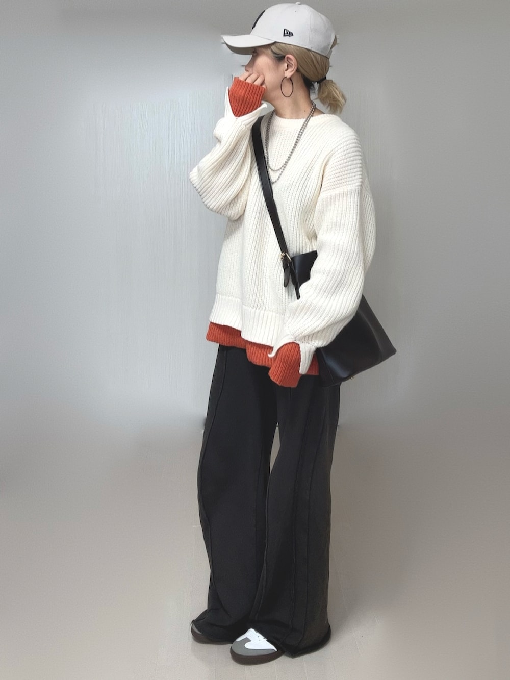 ブラック系のスウェットパンツ、ホワイト系のニット/セーター、ホワイト系のキャップを着用したレディースの冬コーディネートの3枚目の写真
